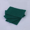 A stack of dark green microfiber kitchen scrub sponges for dishes and countertops.