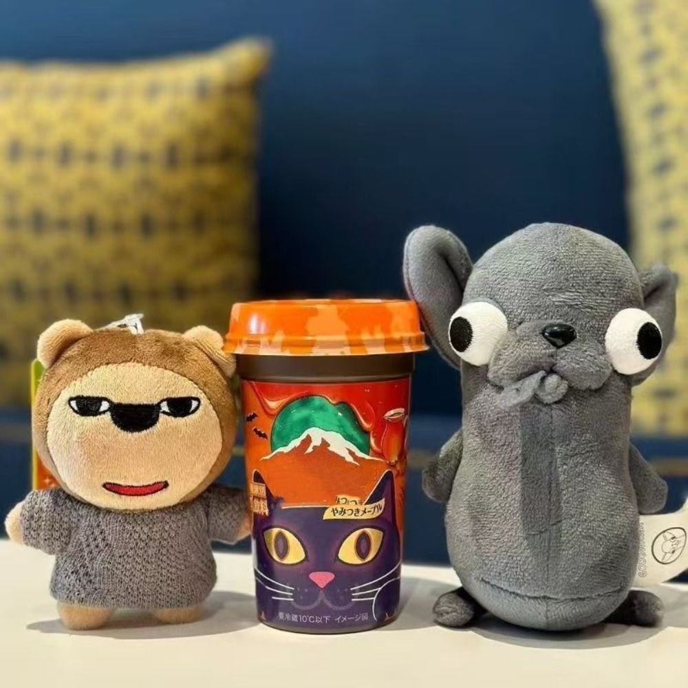 A plush chihuahua dog keychain pendant next to a gray elephant plush toy.
