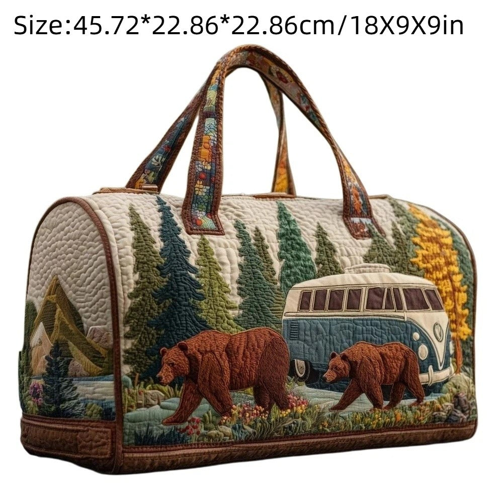 A quilted travel duffle bag with brown leather handles and 3D stitching featuring a forest and bear design.