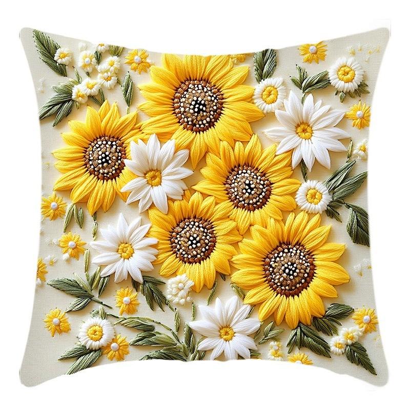 A floral cushion cover featuring yellow and white sunflowers and greenery.