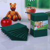 A stack of green microfiber cleaning cloths next to a small stuffed lion and a red tomato.