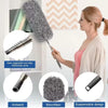 A woman is using a microfiber duster with a telescopic extension pole for cleaning.
