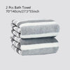 A stack of two gray and white striped bath towels is shown.