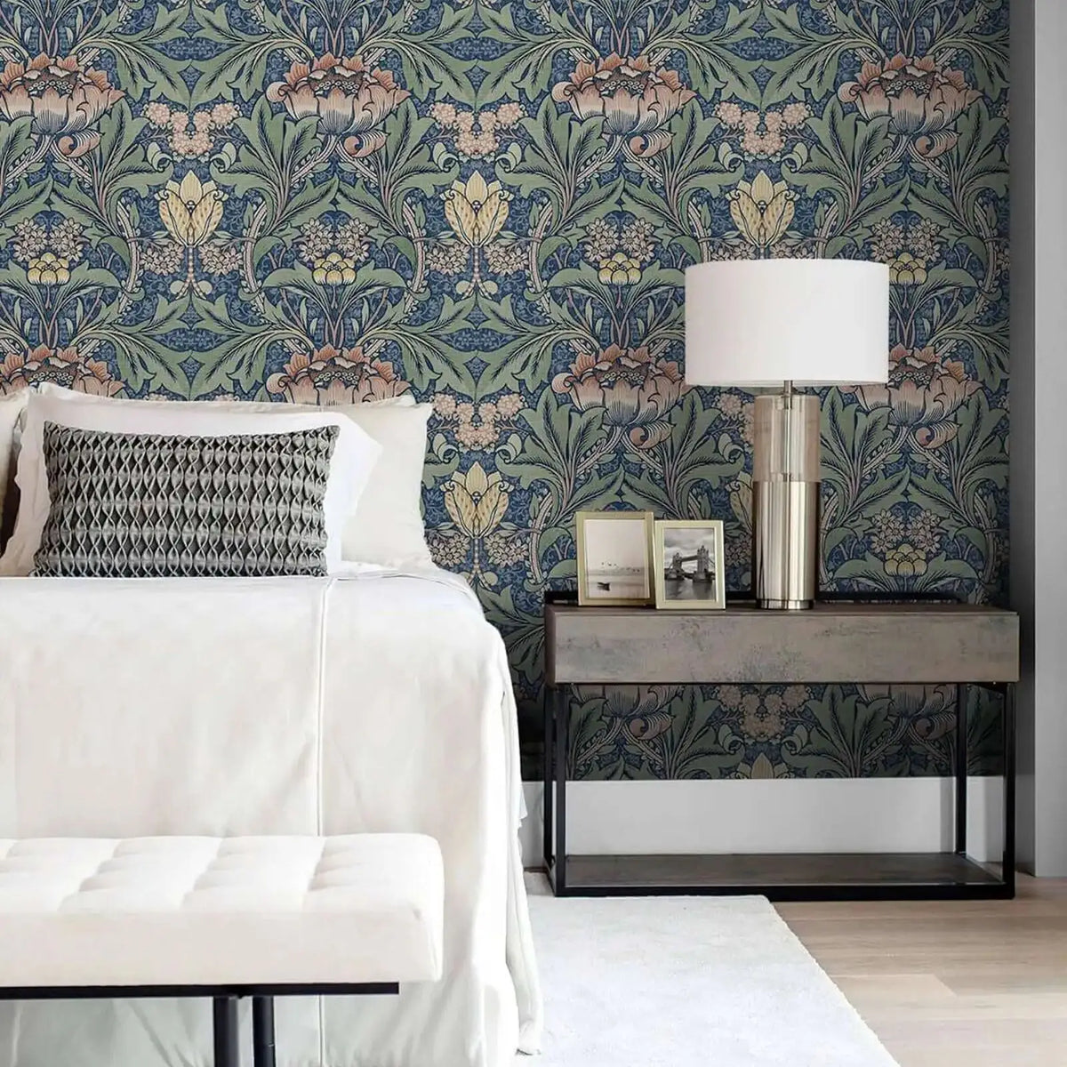 A bedroom featuring a headboard and nightstand decorated with blue vintage damask floral wallpaper.