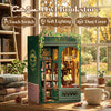 A wooden Owl Bookstore miniature display cabinet with glass doors and internal lighting on a wooden surface.