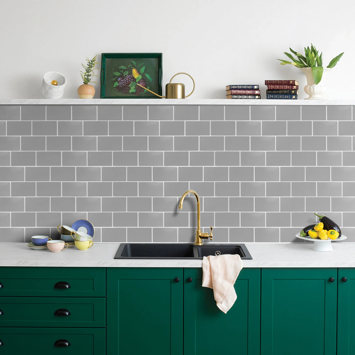 A kitchen countertop with a black sink, green cabinets, and a gray subway tile backsplash.