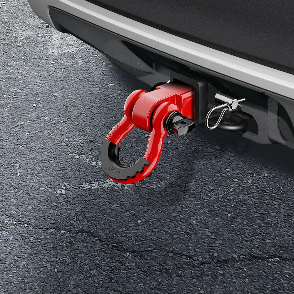 A red heavy-duty shackle with a D-ring and trailer pin is attached to a vehicle's hitch receiver.