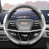 Close-up view of a glossy carbon fiber steering wheel cover inside a modern car cockpit.