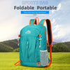 A teal foldable portable mountaineering backpack is shown outdoors on a grassy field.