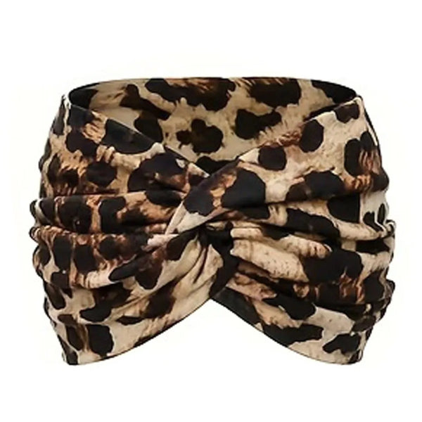 A patterned fabric headband featuring a black and white leopard print tied in a knot.