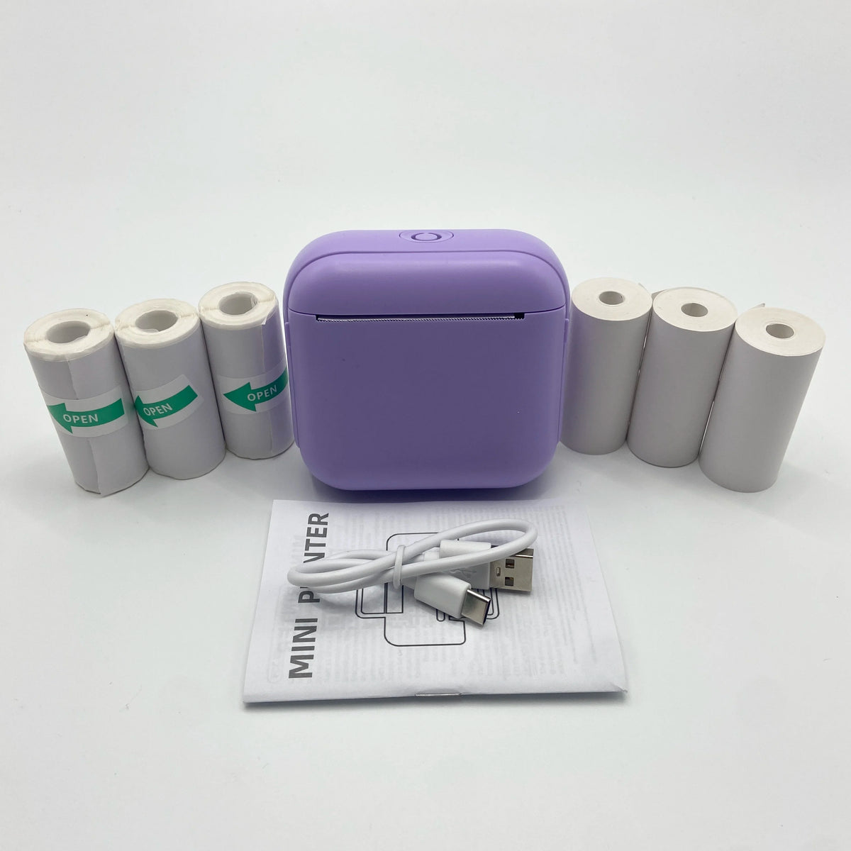 Imprimante thermique Bluetooth portable violette avec plusieurs rouleaux de papier blanc et un câble d'alimentation sur fond 