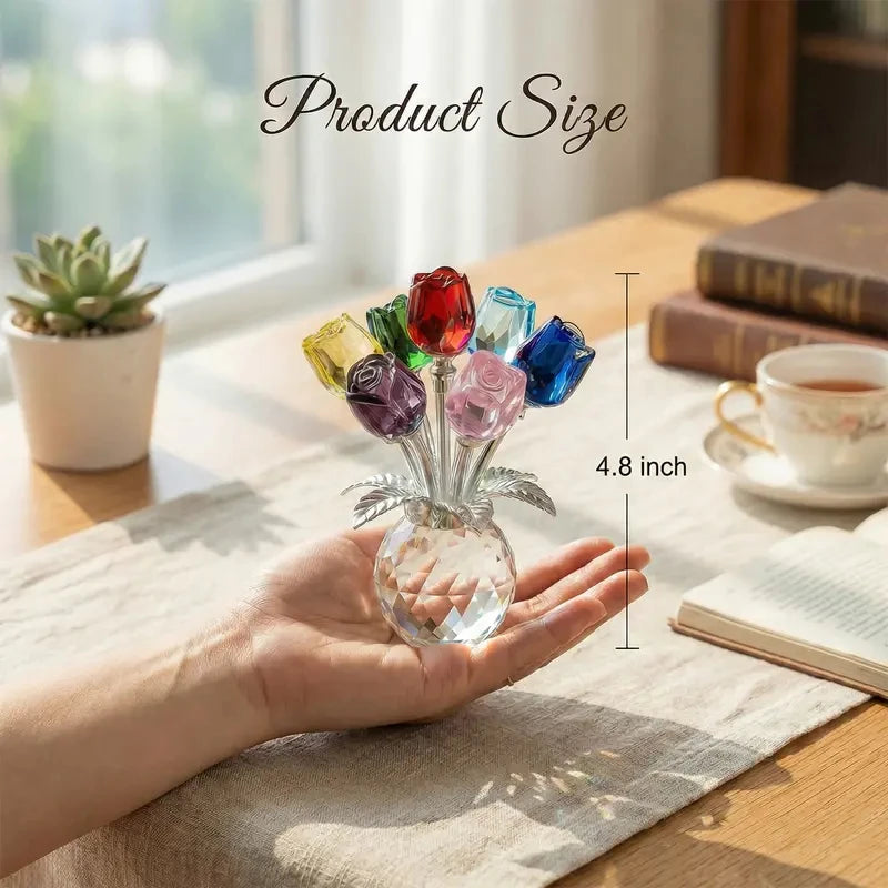 Eine Hand hält eine Kristallrose-Figur mit einer Glasvase auf einem Holztable.