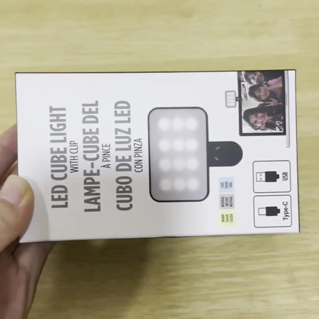 A white box for a LED cube light with clip and a selfie light.