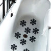 Black snowflake anti-slip stickers placed on a white ceramic bathroom sink.