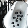 White ceramic bathtub with black snowflake anti-slip stickers placed on the surface.