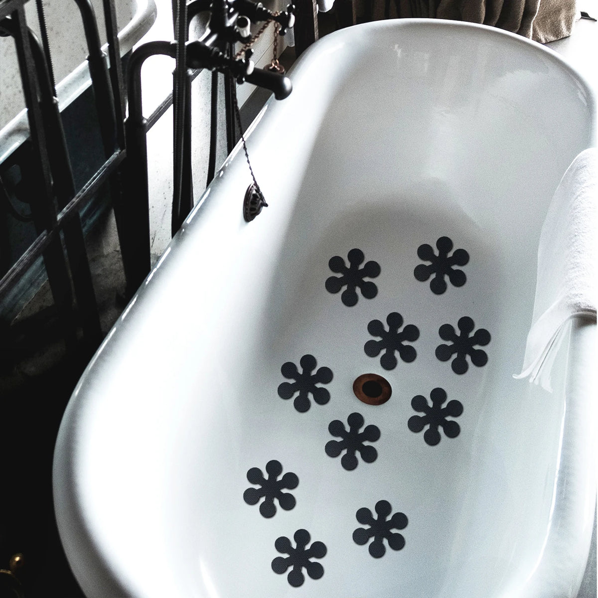 White ceramic bathtub with black snowflake anti-slip stickers placed on the surface.