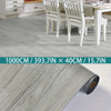 Roll of light gray wood grain laminate flooring material shown next to a dining room setting.