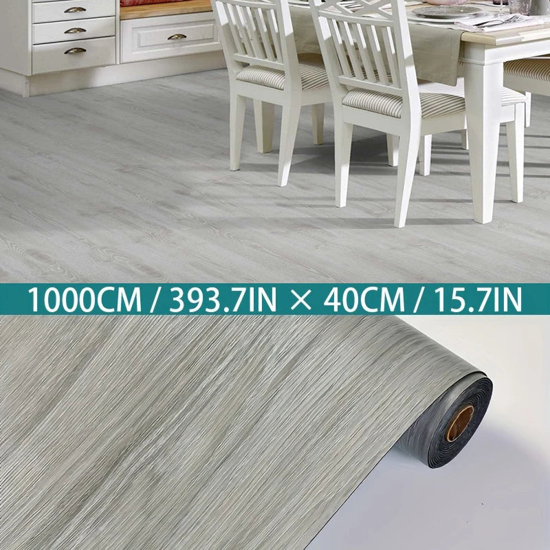 Roll of light gray wood grain laminate flooring material shown next to a dining room setting.