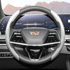 Close-up view of a glossy carbon fiber steering wheel cover inside a modern car cockpit.