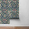 Blue vintage damask floral peel and stick wallpaper featuring green leaves and pink flowers.