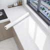 A roll of pearl finish waterproof self-adhesive wallpaper displayed on a white countertop near a window.