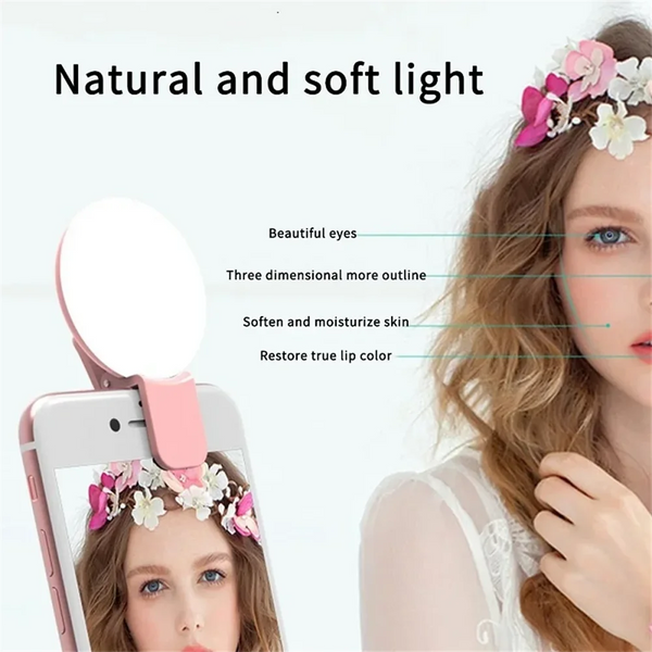 A woman is using a mini clip-on LED selfie ring light to enhance her features and skin.