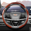 Close-up view of a steering wheel with an orange and black patterned leather cover and a central emblem.