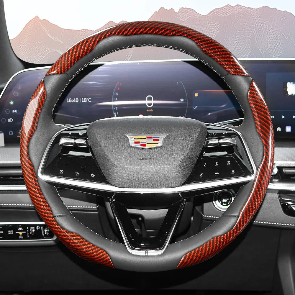Close-up view of a steering wheel with an orange and black patterned leather cover and a central emblem.
