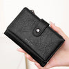 Une main tient un porte-monnaie portefeuille bi-pli en cuir noir bloqueur RFID.