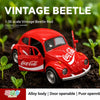 A red 1:36 scale Vintage Beetle die-cast model car with an open door, placed in a green plant environment.