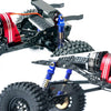 Close-up of an aluminum shock absorber set with black and red components and a tire on a RC crawler.