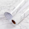 Roll of pearl finish waterproof self-adhesive wallpaper lying on a white marble surface
