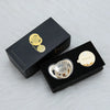 A black box containing a personalized rhinestone pacifier and clip set with a gold-toned charm.