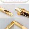 Close-up display of a gold-plated brass tenor saxophone mouthpiece with decorative engraving.