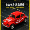 A red vintage Volkswagen Beetle die-cast model car with Coca-Cola decals driving on a dark asphalt road.