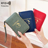 A hand holds a green RFID blocking passport wallet and a red passport wallet, demonstrating protection.