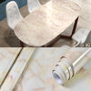 Roll of marble peel-and-stick wallpaper showing pink and white veining for kitchen or living room decor