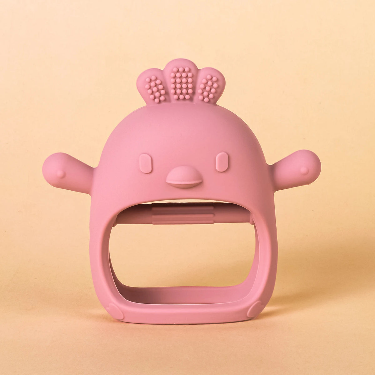 A pink silicone teether shaped like a chick with a textured top and small ears.