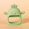 A light green silicone teether shaped like a chick with a wide opening for baby gums.