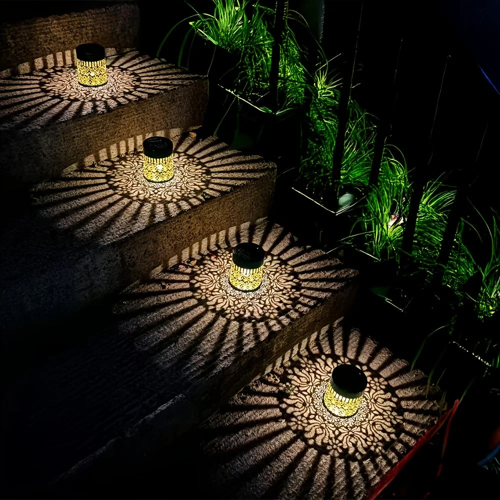 A series of tiered outdoor lights resembling peonies cast patterned shadows on the ground.