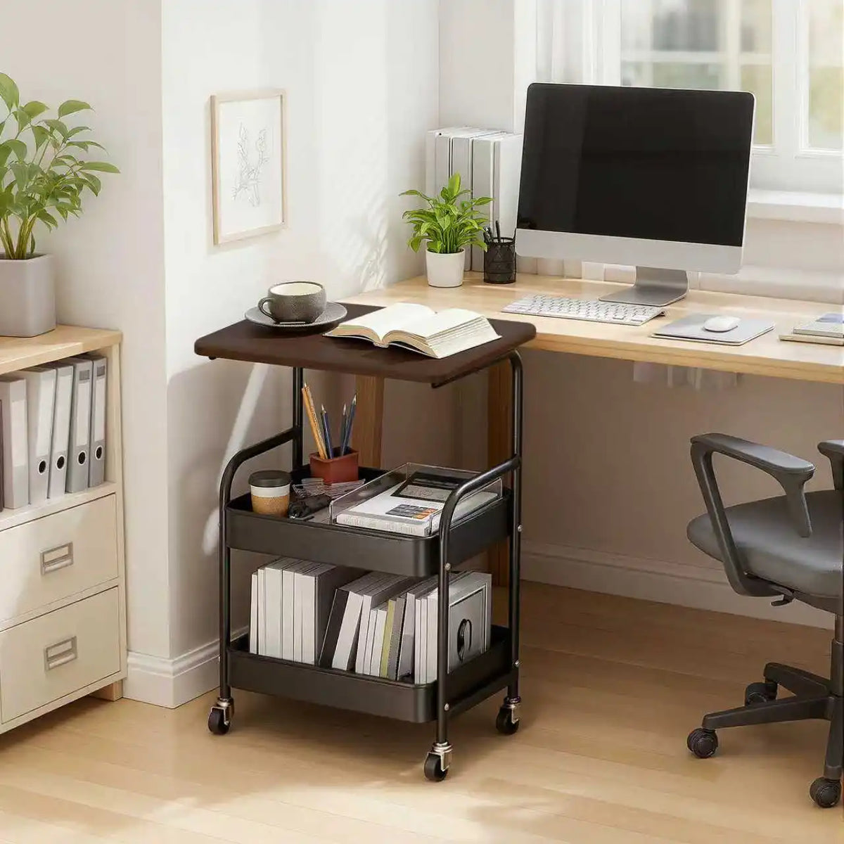 A black 3-tier rolling utility cart with a wooden top and lockable wheels is positioned next to a desk.