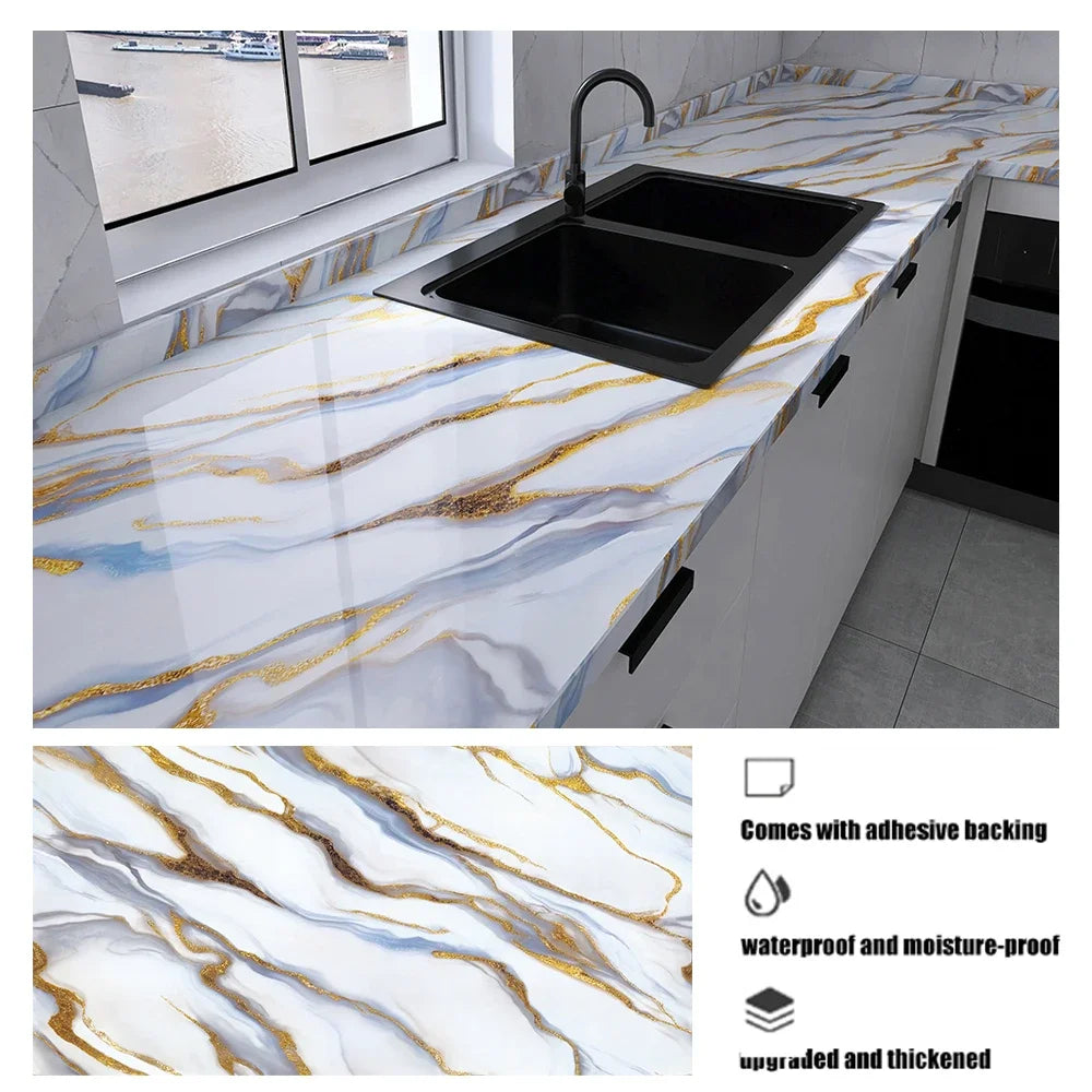 A black kitchen sink installed in a white countertop featuring marble pattern with gold veining.
