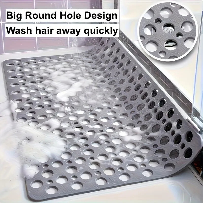 A close-up of a metal shower mat with numerous drainage holes and massage points designed to wash hair away quickly.