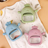 Two silicone chick-shaped teethers in green and pink are displayed on a white shirt.
