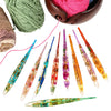 A set of epoxy resin floral-patterned crochet hooks and yarn spools in various colors.