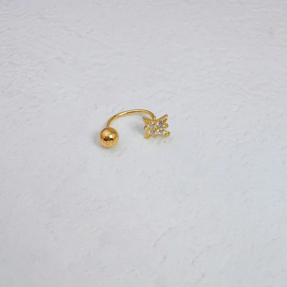 A gold nose ring featuring a spherical stud and a star-shaped gemstone.