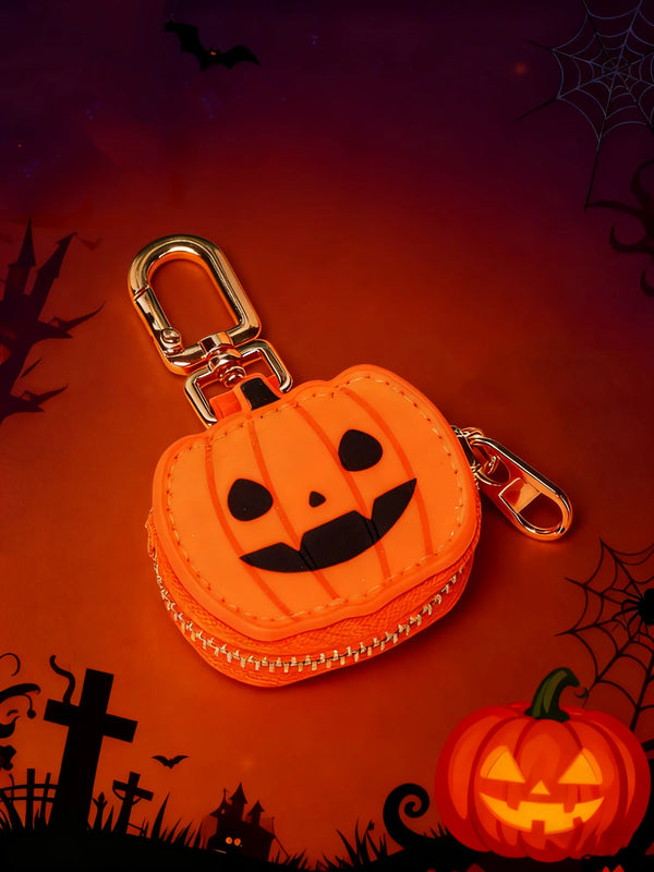 An orange pumpkin coin key chain pouch with a smiling face is displayed on a dark background with spiderwebs and bats.