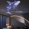 An LED USB projector light displays glowing whale, butterfly, and star patterns on a ceiling.