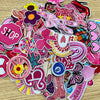 A collection of pink embroidered cartoon iron-on patches featuring various shapes and designs.