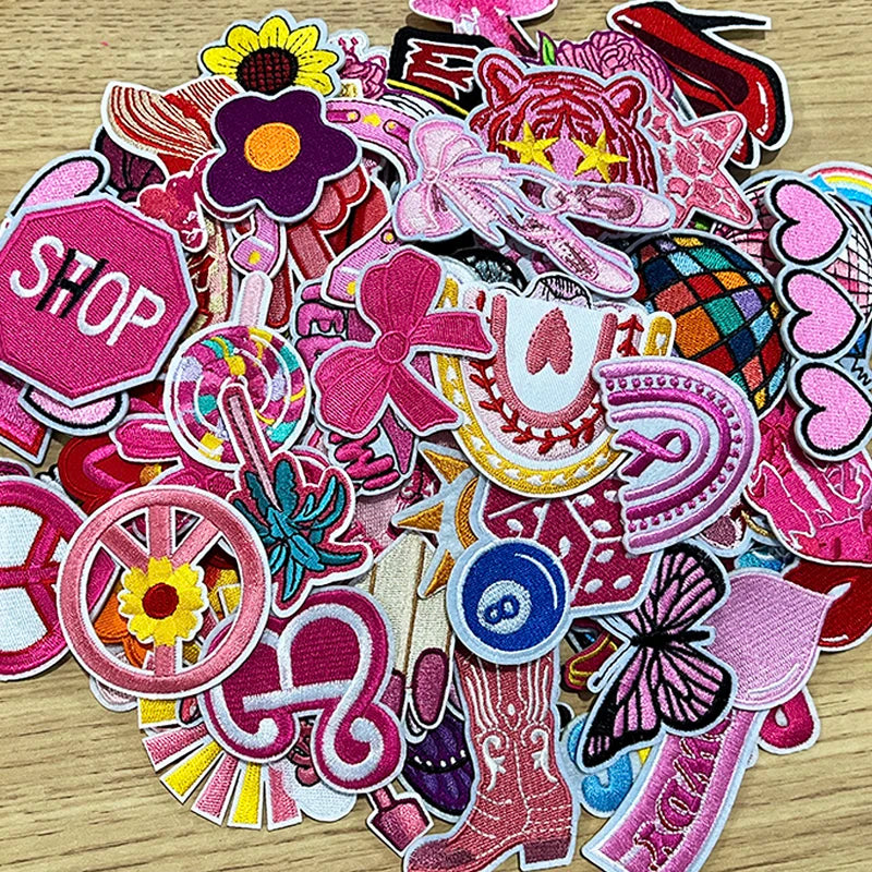A collection of pink embroidered cartoon iron-on patches featuring various shapes and designs.